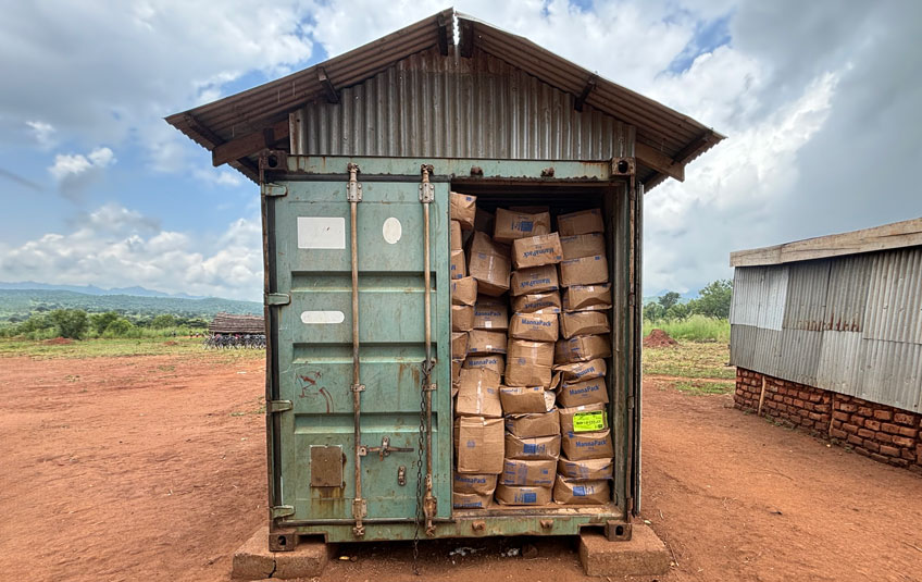 An open shipping container full of FMSC meals in Nakwanya, Uganda