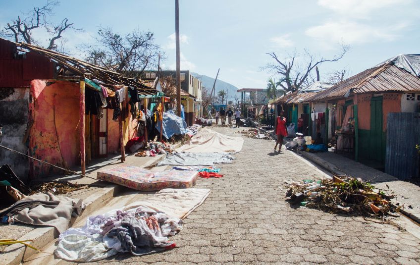 Street littered with debris and fallen trees after a hurricane